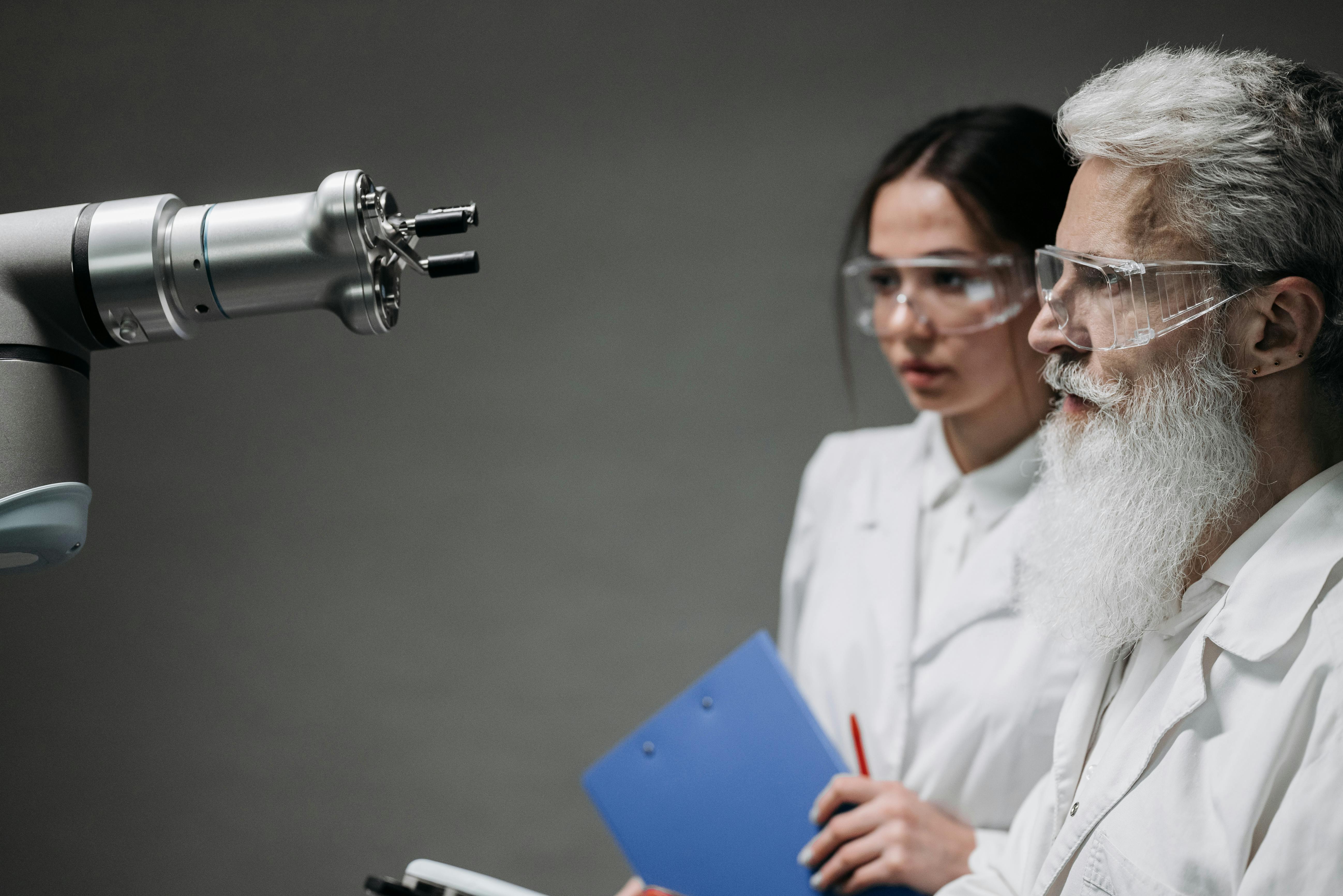 Two scientists wearing lab coats analyzing robotic equipment in a laboratory setting