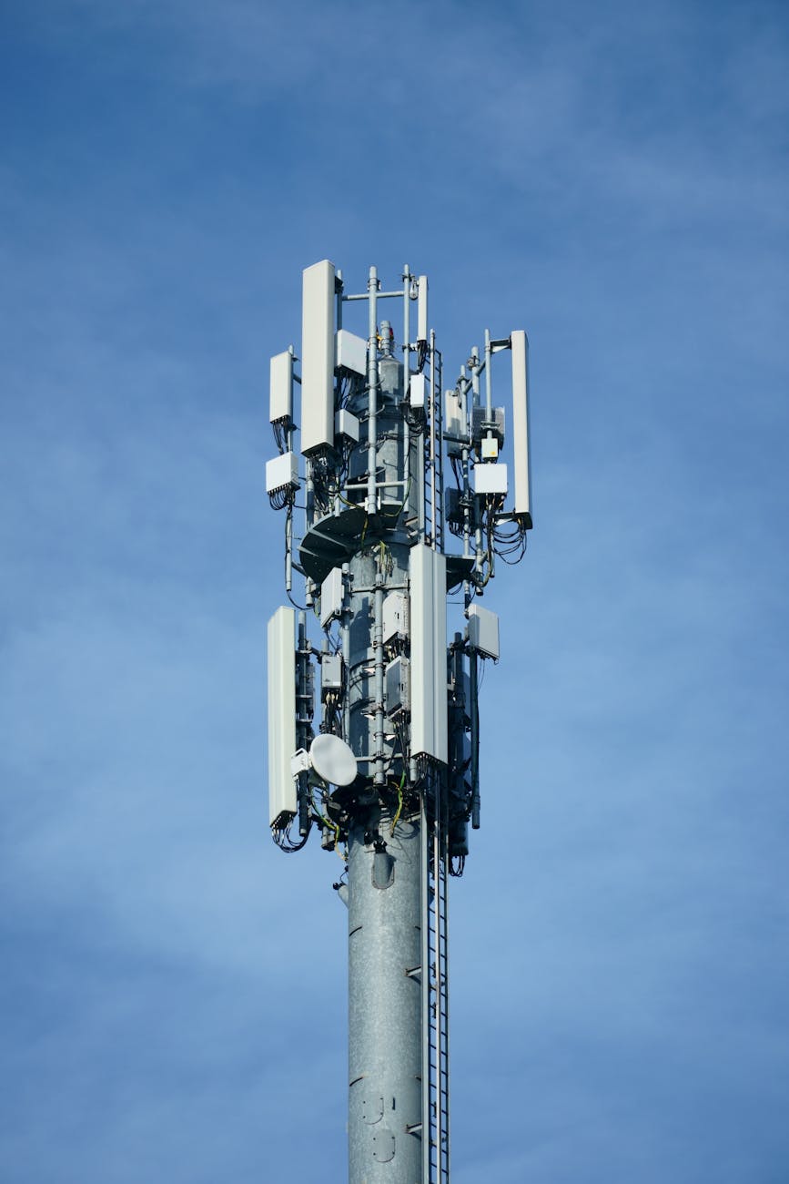 Telecommunication transmission tower with multiple antennas against a clear blue sky
