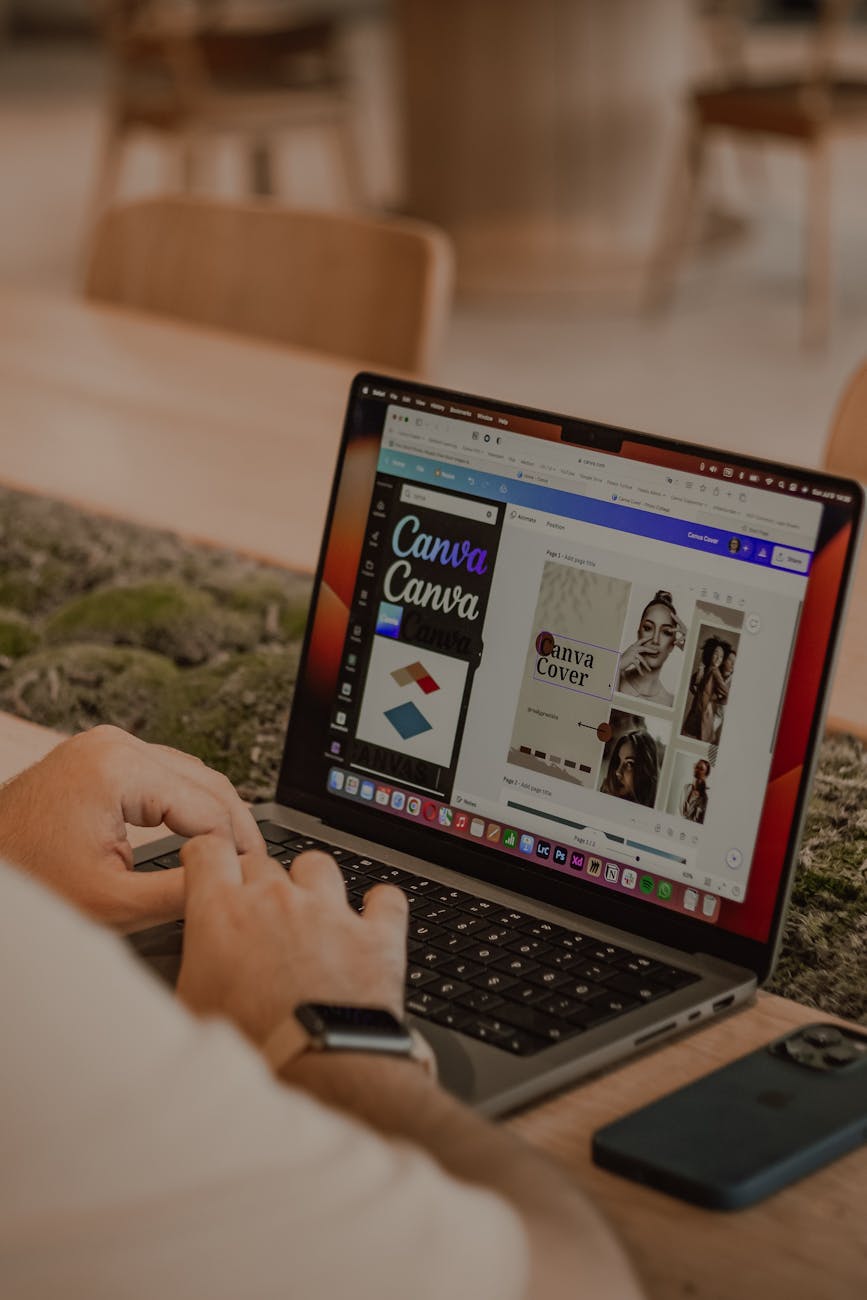 Close-up of a person using a laptop to design with Canva
