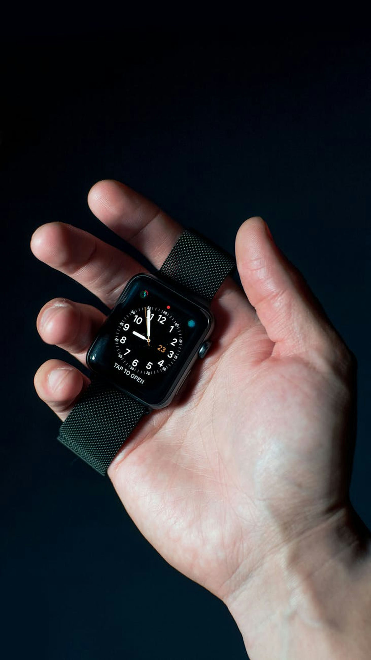 Hand holding an Apple Watch showing the Digital Crown and side button