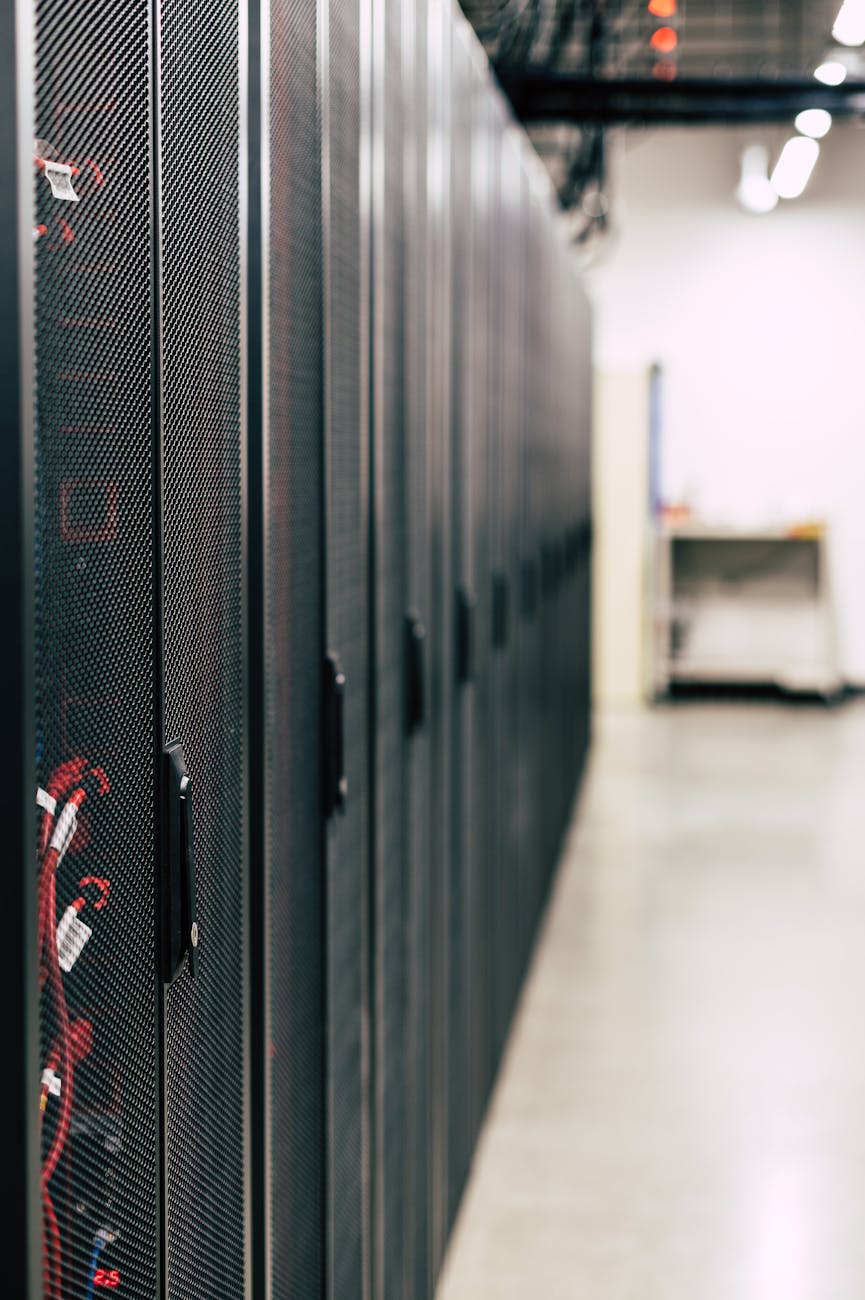 Rows of black server cabinets with red optical fibre cables in a data centre
