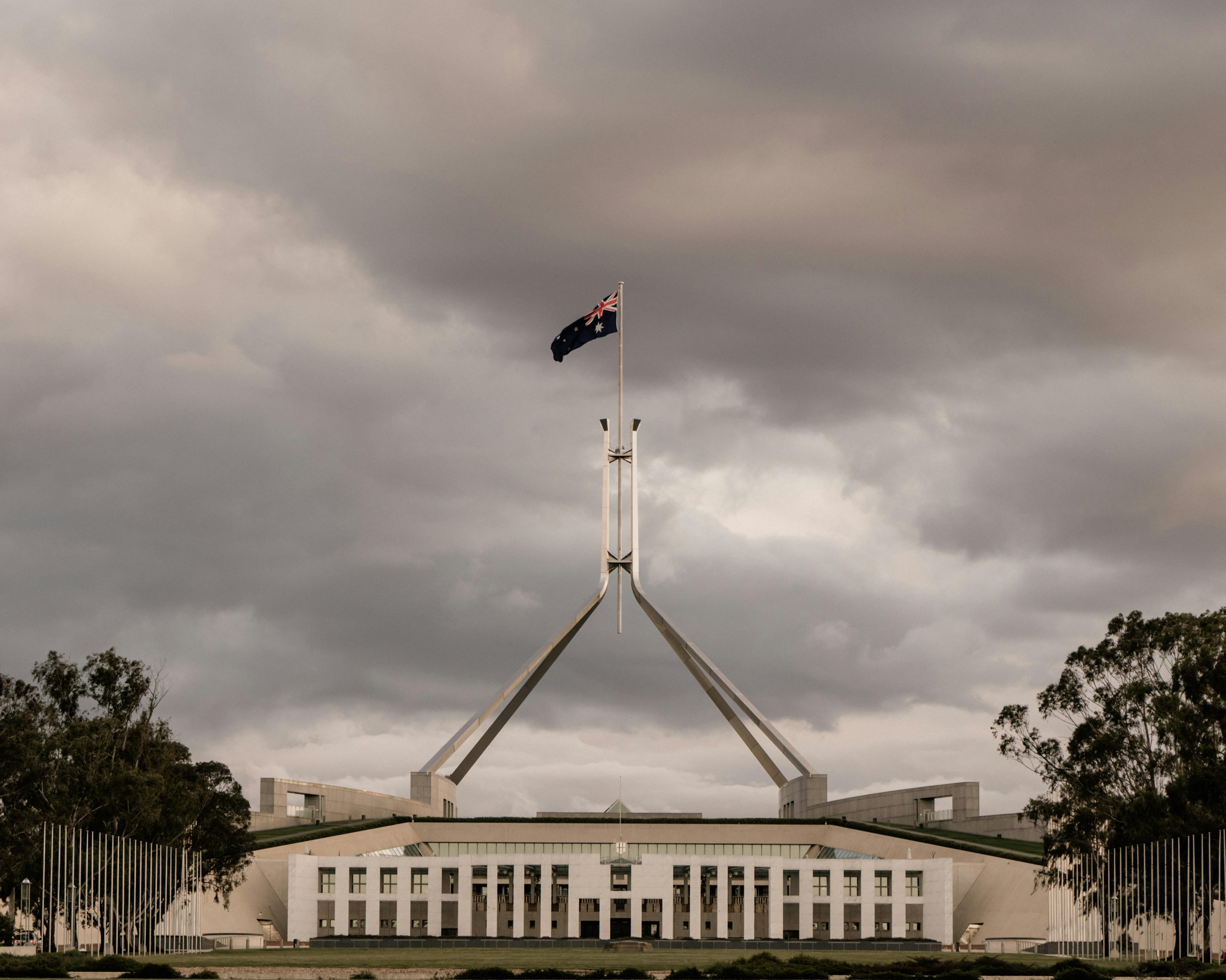 Australian Parliament House in Canberra with a dramatic cloudy backdrop
