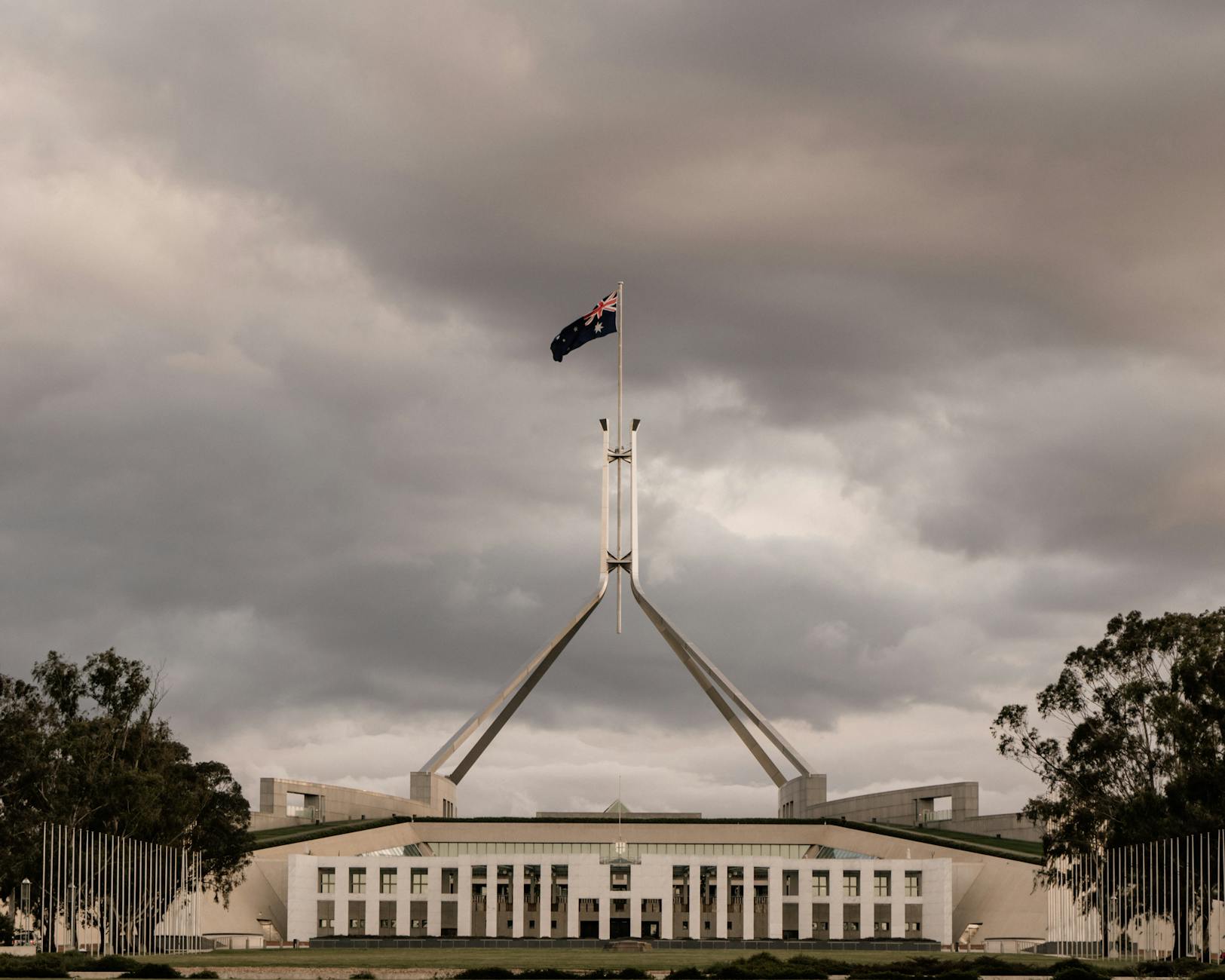 The Parliament House of Australia in Canberra with a dramatic cloudy backdrop