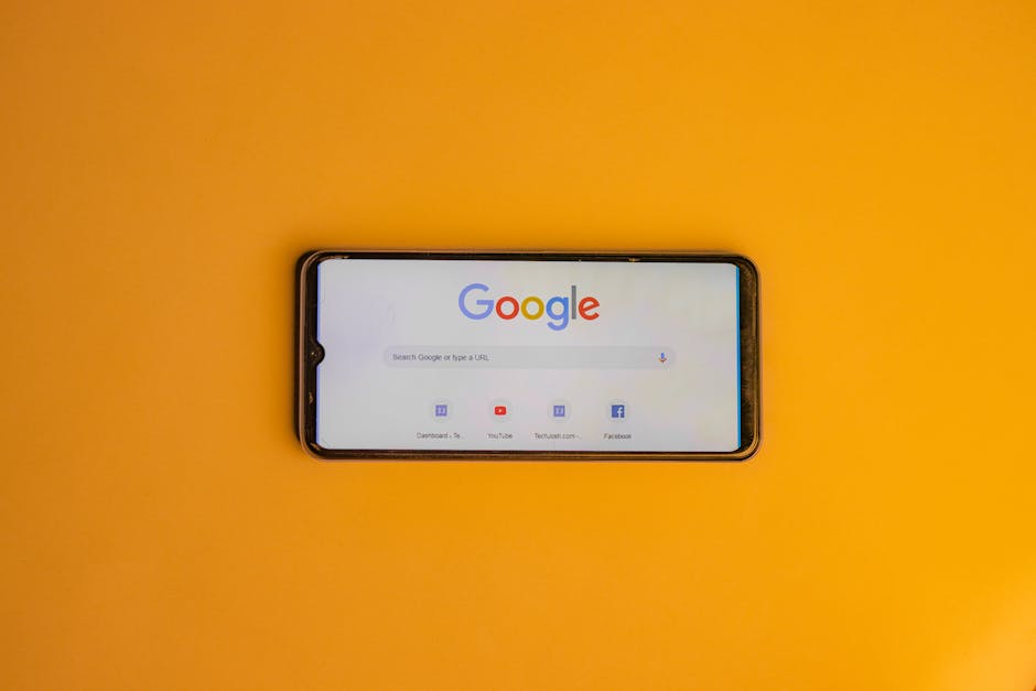 Smartphone displaying Google search page on a vibrant yellow background