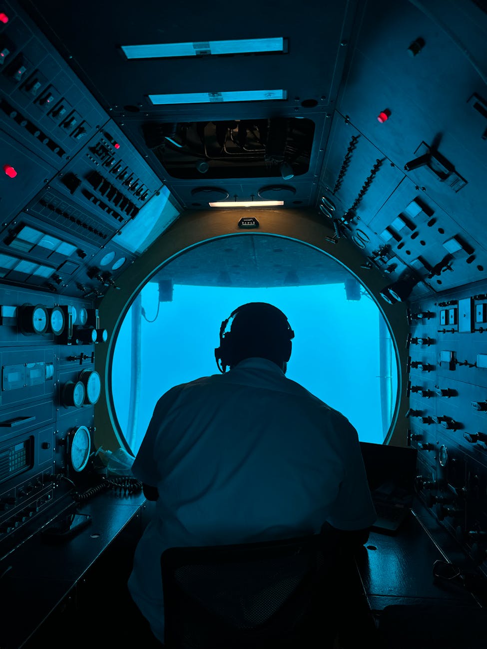 Operator in submarine control room analyzing equipment