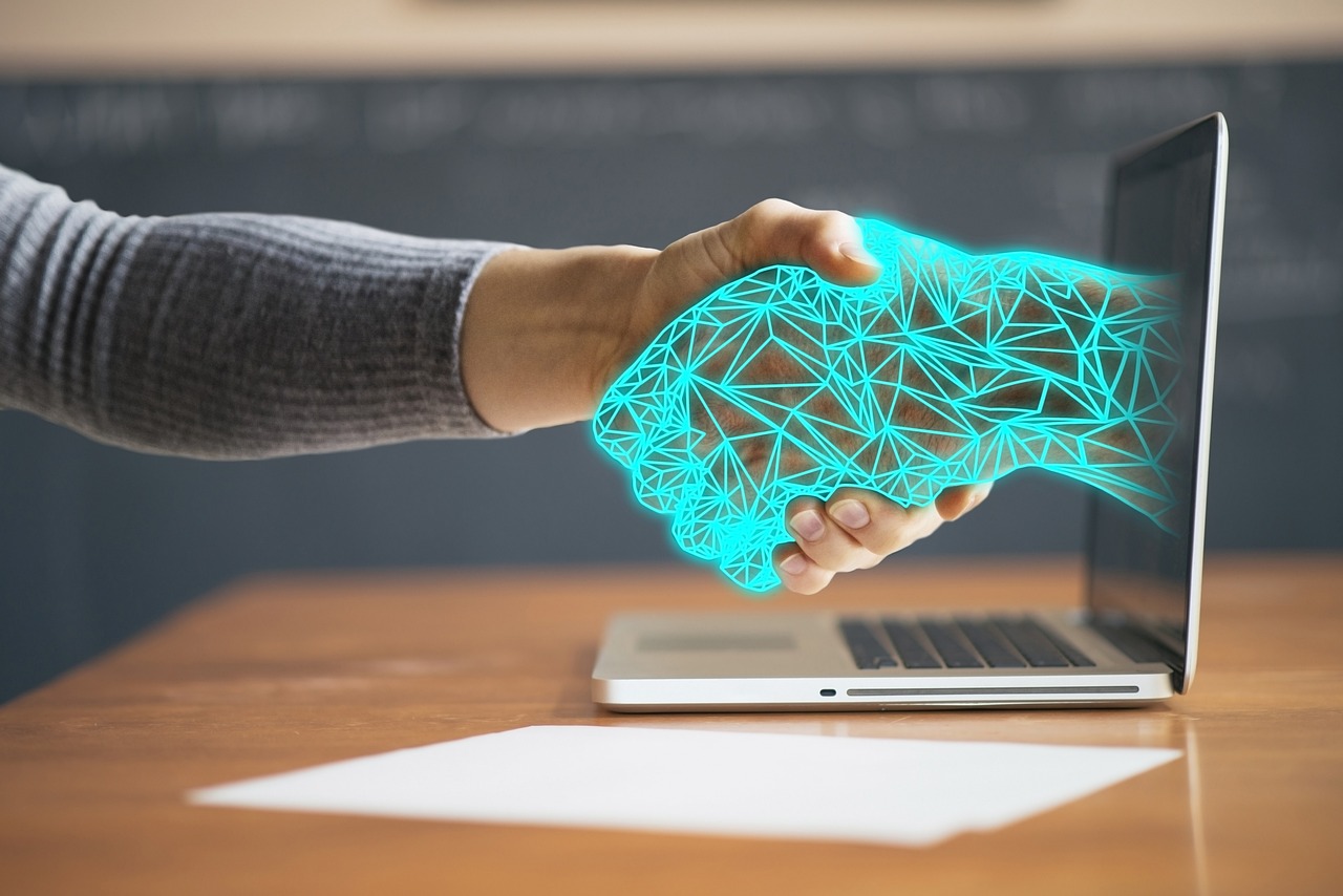Futuristic robotic hand touching a human hand in a digital handshake, representing AI and business partnership