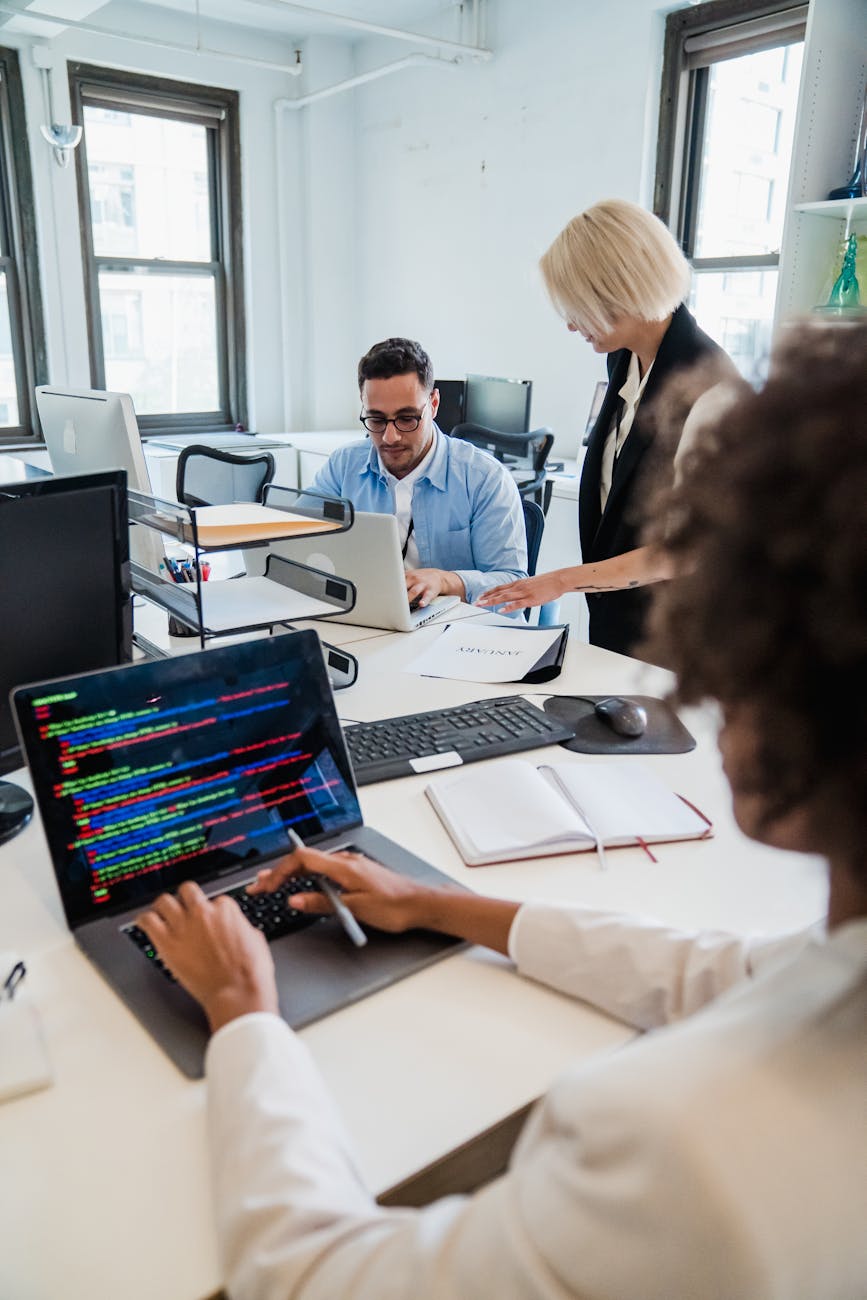 Team of professionals collaborating in a modern office on software projects