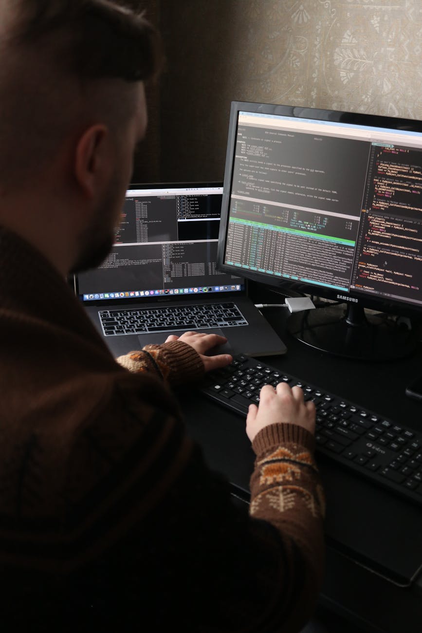 Programmer working across multiple screens, reflecting the convergence of AI chat, coding and tool workflows.