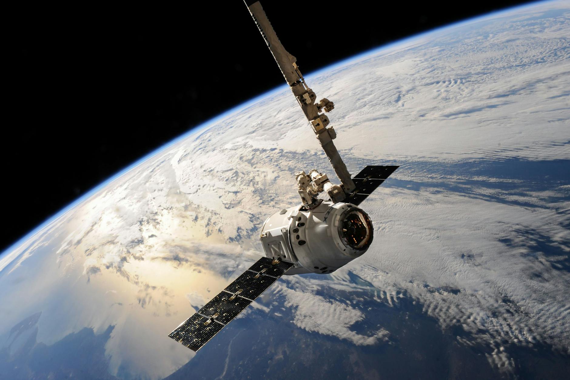 A satellite glides over Earth showcasing cloud systems from orbit.