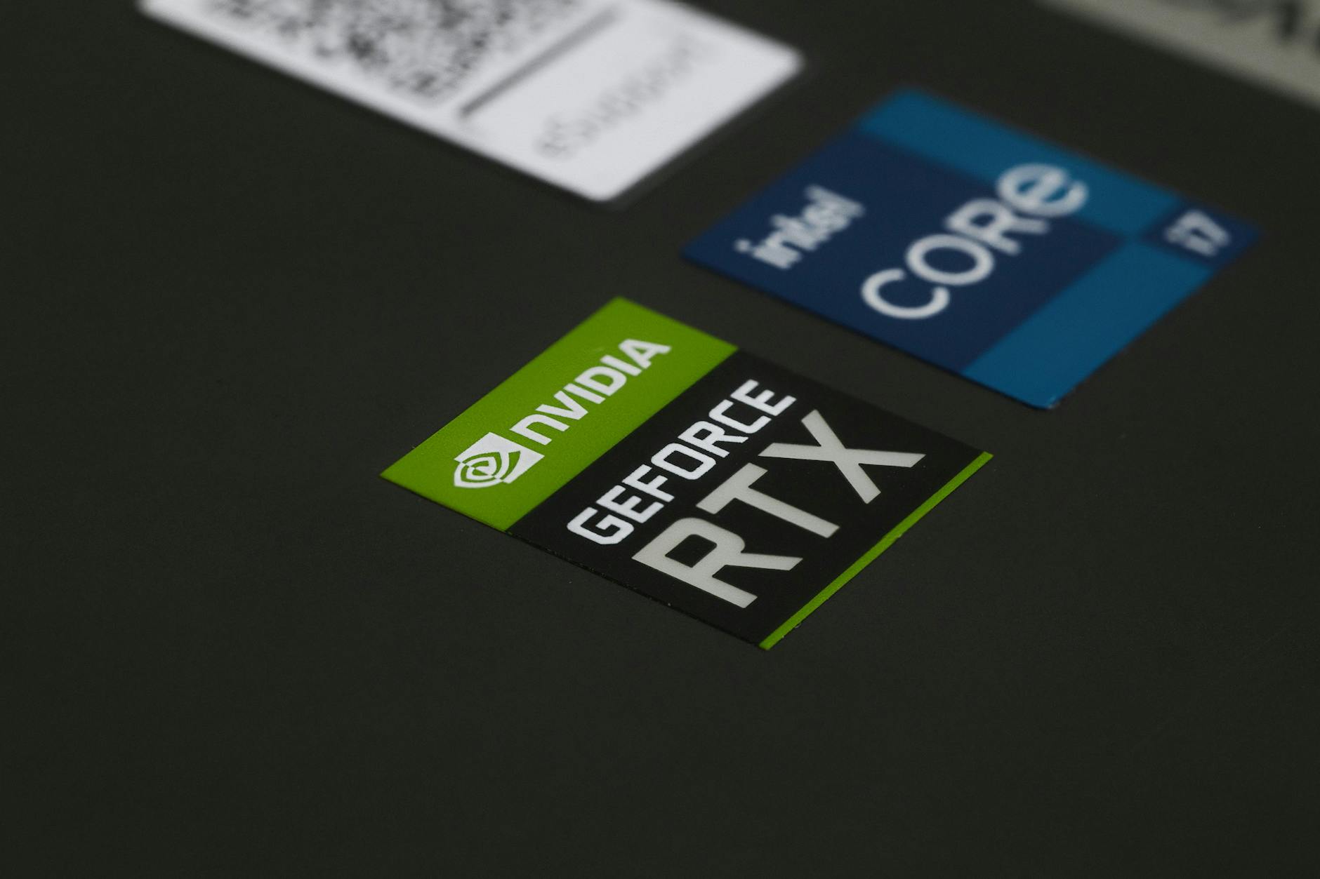 NVIDIA and Intel hardware stickers on a laptop, reflecting the AI PC processor race