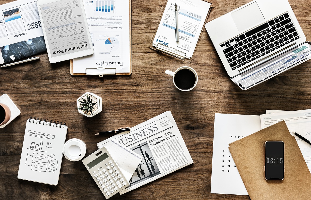 Laptop, notes and business documents on a desk, illustrating AI tools moving into office workflows