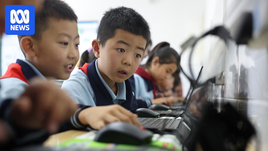 Students in school uniform look at a laptop during an AI education lesson