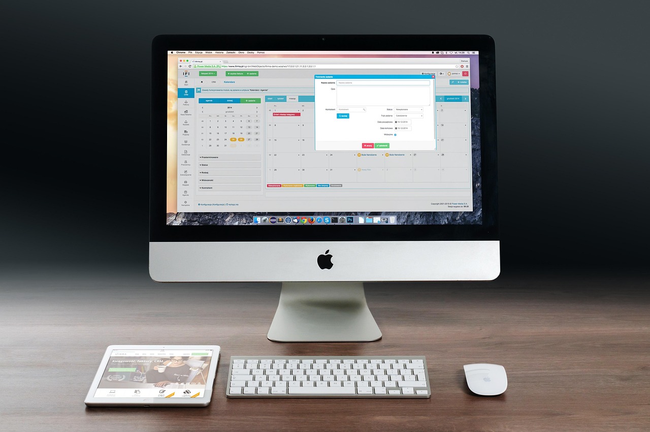 Apple products — iPhone, iPad, and MacBook on a workplace desk