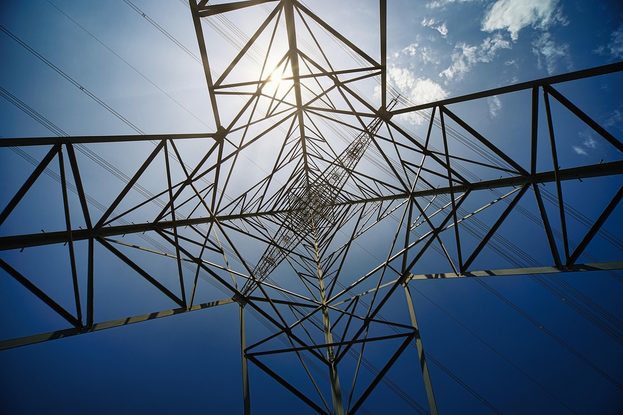 High-voltage power lines at sunset, reflecting the grid constraint behind AI data-centre growth.