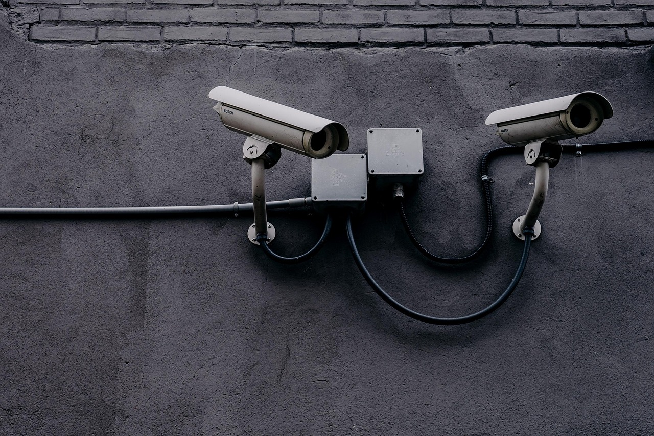 Security camera mounted on a building wall, illustrating workplace monitoring and privacy controls.